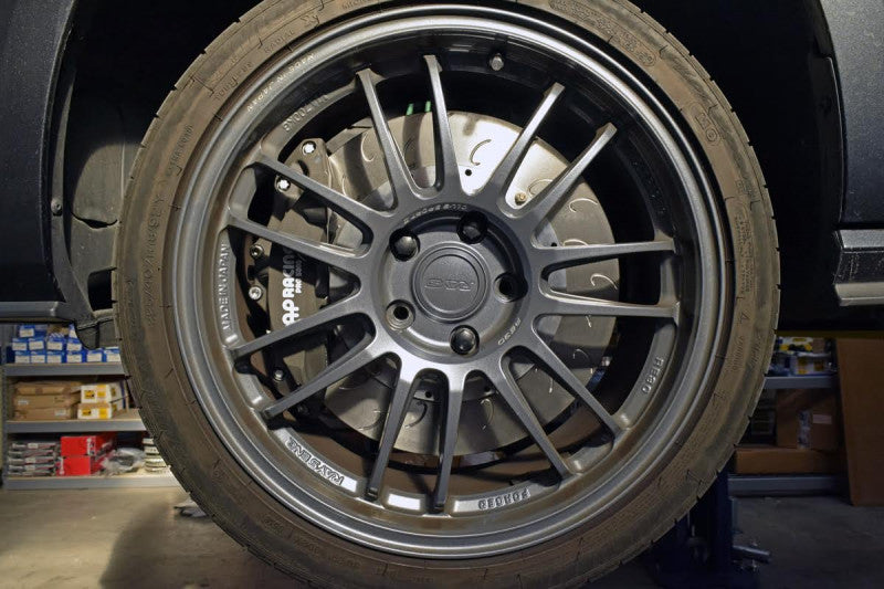 A close up view of a wheel fitted with AP Racing by Essex Radi-CAL ENP Competition Brake Kit (Front CP9660/372mm)- BMW F87 M2 & M2 Competition, F80 M3, F82 M4