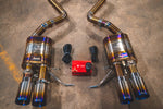 A close up view of Valvetronic Designs Titanium Valved Sport Exhaust System's mufflers, exhaust tips and valve controller, on the ground (for BMW M3 E9X).