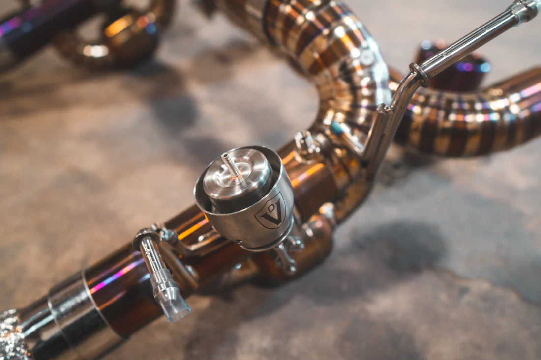A close up view of Valvetronic Designs Valved Sport Exhaust System on the ground (for Ferrari F8).