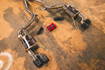 A side close up view of Valvetronic Designs Valved Sport Exhaust System with valve controllers and wires on the ground (for Ford Mustang GT S550).