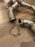 A close up view of Valvetronic Designs Free Flow Front Pipes on a wooden floor (for Mercedes AMG GT/ GTC / GTR).