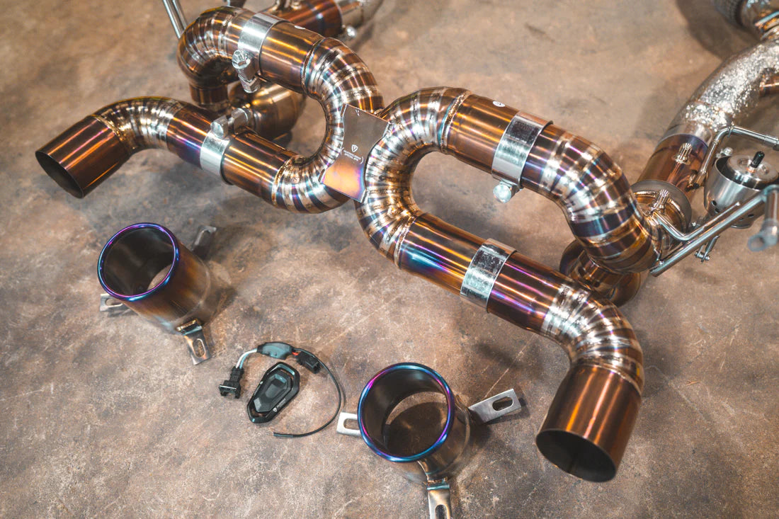 A top close up view of Valvetronic Designs Valved Sport Exhaust System with all its parts on the ground (for Ferrari F8).