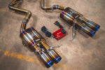 A close up view from the top of Valvetronic Designs Titanium Valved Sport Exhaust System's mufflers, exhaust tips and valve controller, on the ground (for BMW M3 E9X).