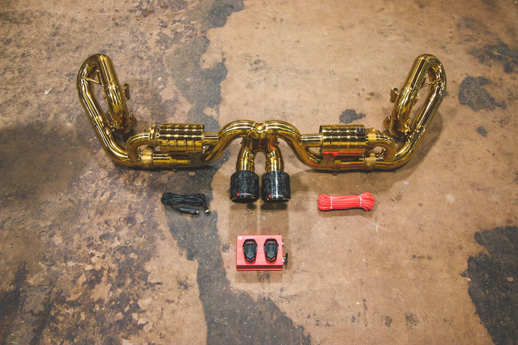 A top overview of Valvetronic Designs Valved Sport Exhaust System with valve controllers and wires on the ground (for Porsche 991 GT3 / RS).