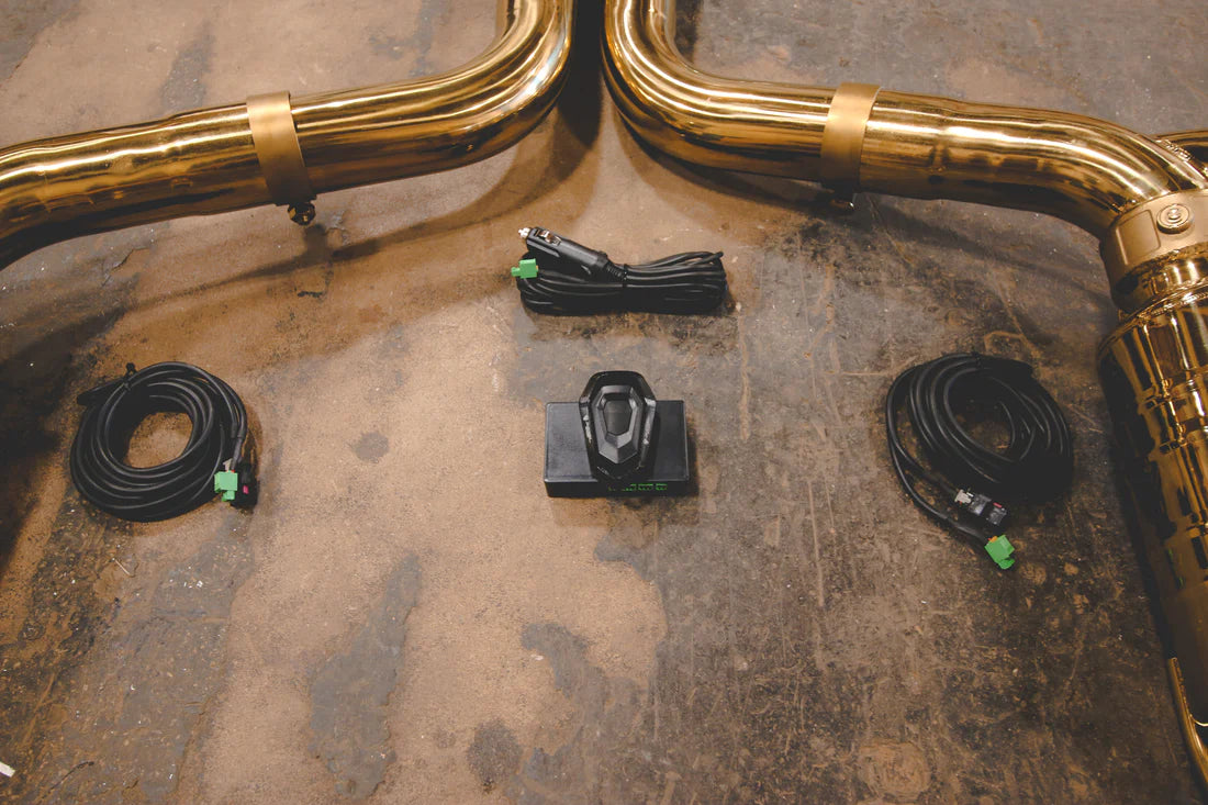 A close overview of Valvetronic Designs Stainless Steel Valved Sport Exhaust System's valve controller and wires on the ground (for Mercedes W205 C63 / C63s).