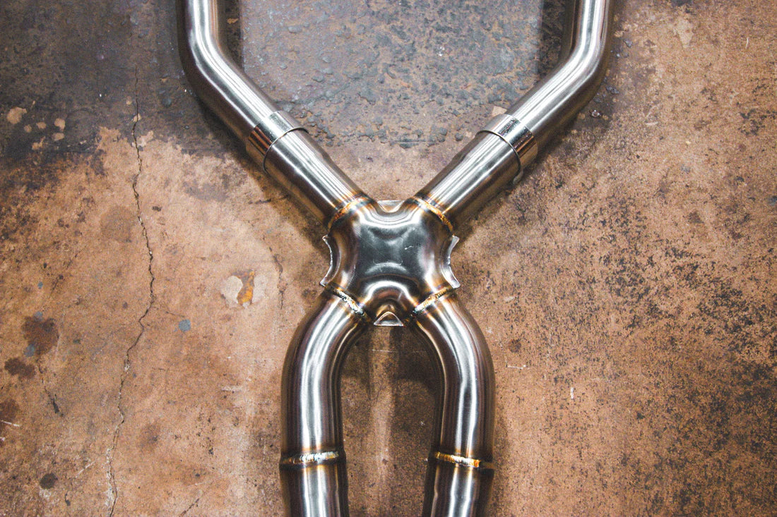 A close up view of a part of Valvetronic Designs Valved Sport Exhaust System (V2) on the ground (for BMW E9x M30).