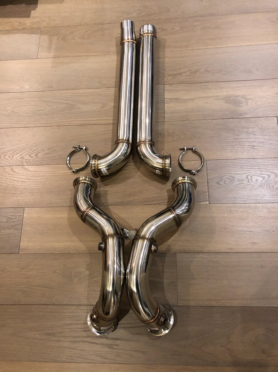 A top view of Valvetronic Designs Free Flow Front Pipes on a wooden floor (for Mercedes AMG GT/ GTC / GTR).