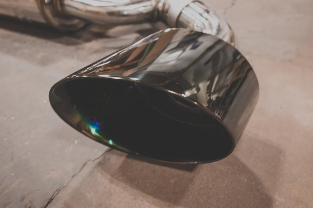 A close up view of the head of Valvetronic Designs Valved Sport Exhaust System pipe (for Audi TTRS MK3) on the ground.