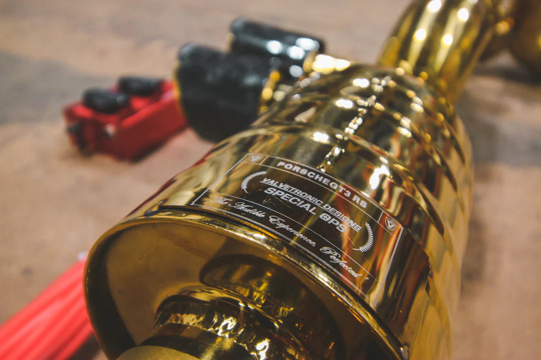 A close up view of Valvetronic Designs Valved Sport Exhaust System's muffler on the ground (for Porsche 991 GT3 / RS).