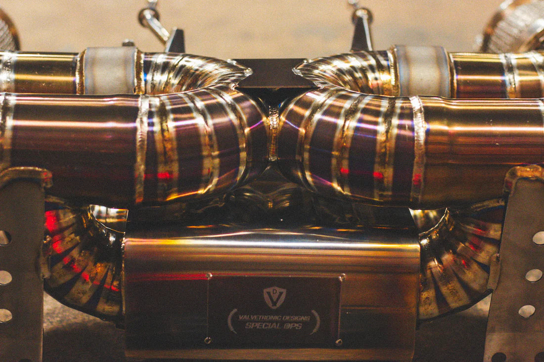 A close up view of Valvetronic Designs Titanium Valved Sport Exhaust System on the ground (for Mclaren 720S).