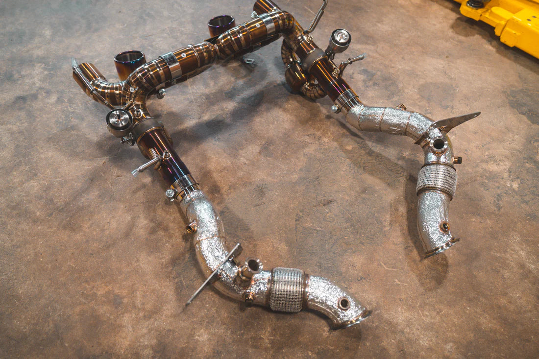 A top wide view of Valvetronic Designs Valved Sport Exhaust System with free flow front pipes on the ground (for Ferrari F8).