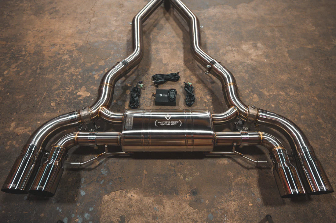A close view of Valvetronic Designs Valved Sport Exhaust System with chrome exhaust tips on the ground (for BMW F90 M5).