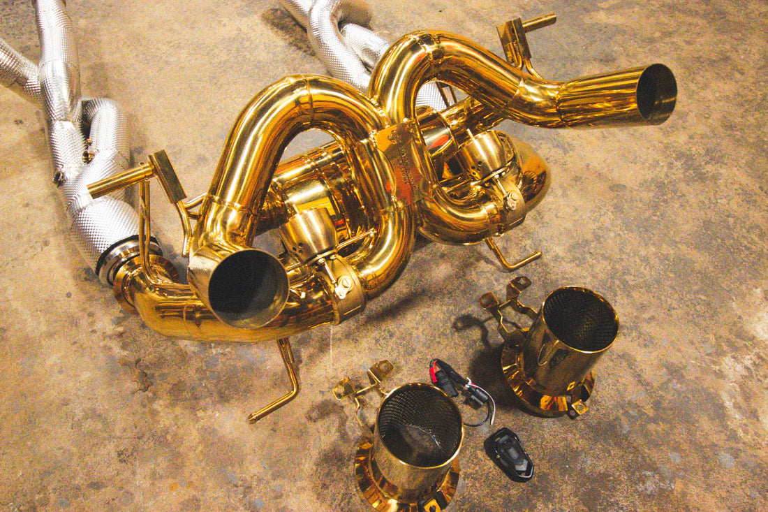 A top view of Valvetronic Designs Valved Sport Exhaust System with free flow front pipes on the ground (for Lamborghini Aventador SVJ/Ultimae).