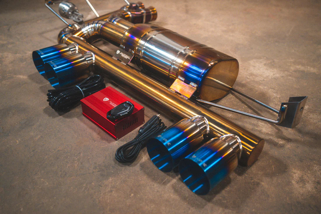 A side overview of Valvetronic Designs Valved Sport Exhaust on the ground with wires and red box (for BMW E46 M3).