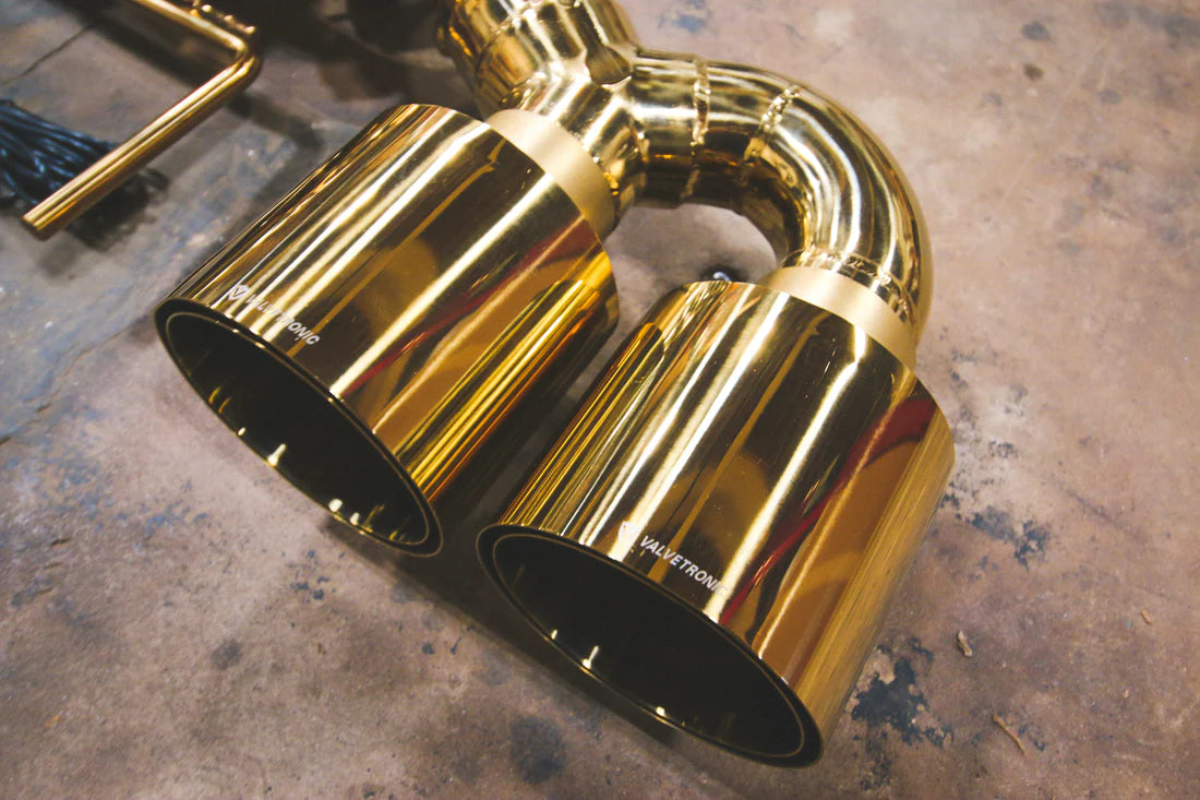 A close up view of Valvetronic Designs Valved Sport Exhaust System's exhaust tips on the ground (for Nissan GTR R35).