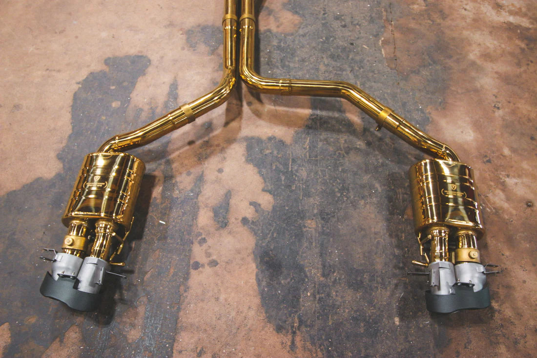 A top view of part of Valvetronic Designs gold Valved Sport Exhaust Sytem (for Audi RS6 / RS7 C7) on the ground.
