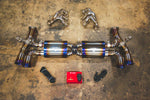A top overview of Valvetronic Designs Valved Race Exhaust System with valve controllers and free flow headers on the ground (for Porsche 991 Turbo / Turbo S).