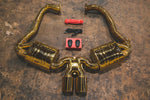 A top overview of Valvetronic Designs Valved Sport Exhaust System with valve controllers and wires on the ground (for Porsche Boxster/Cayman 981).