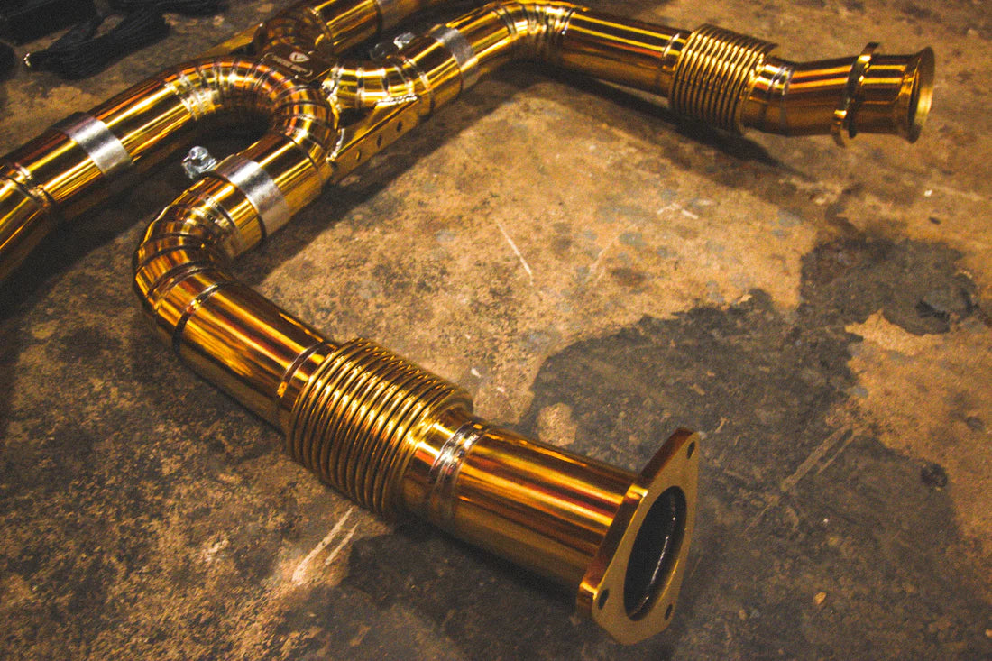 A close up view of Valvetronic Designs Valved Sport Exhaust System's pipes on the ground (for Chevrolet Corvette C8).