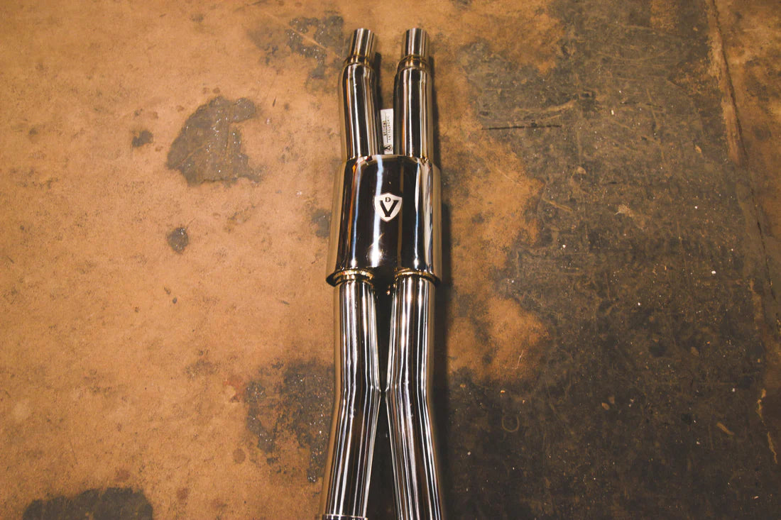 A close up view of Valvetronic Designs Valved Sport Exhaust System's pipes on the ground (for Ford Mustang GT S550)