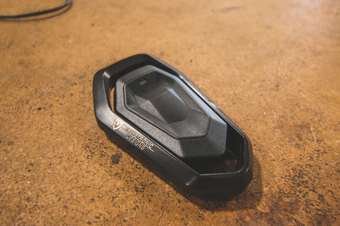 A close up view of Valvetronic Designs Porsche Exhaust Valve Controller on the ground. 