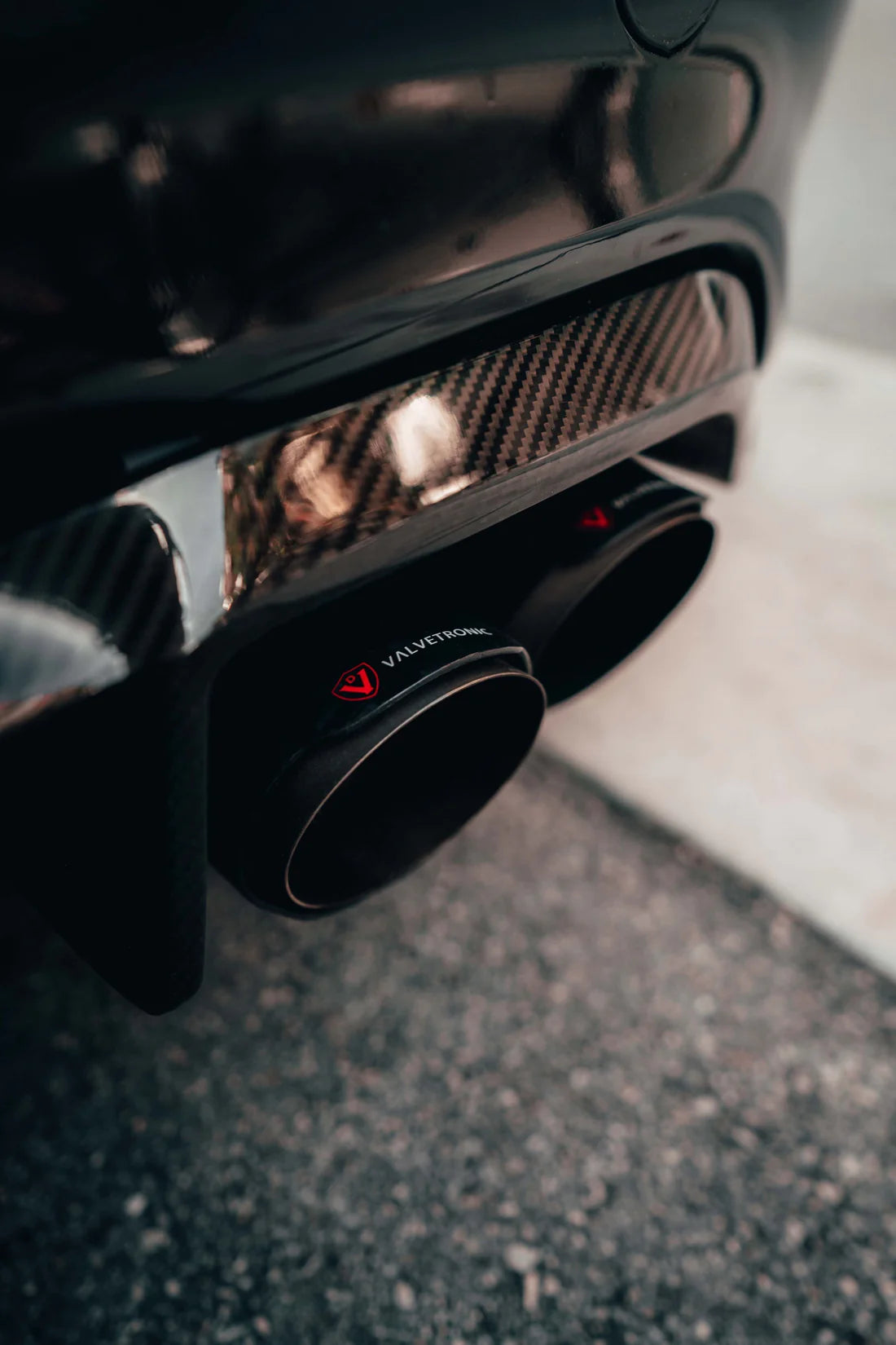 A close view of exhaust tips of Valvetronic Designs Valved Sport Exhaust System fitted on a car on the road (for BMW F87 M2).