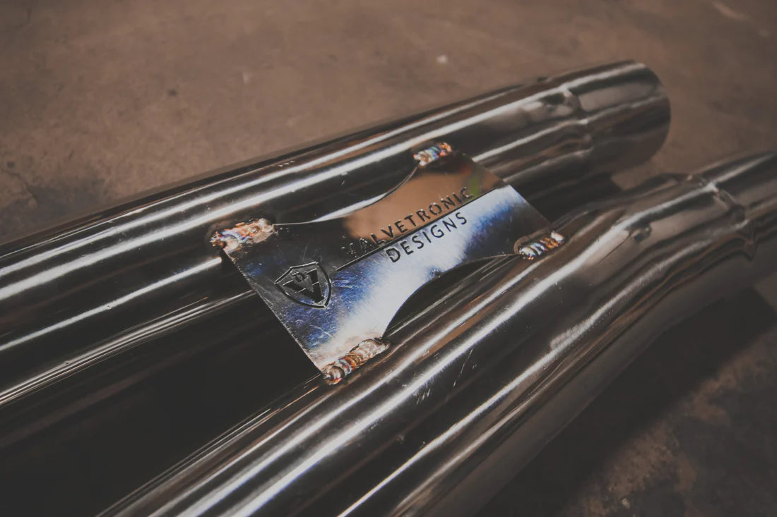 A close up of a part of Valvetronic Designs Valved Sport Exhaust System (for Audi TTRS MK3) showing the brand's logo on the ground