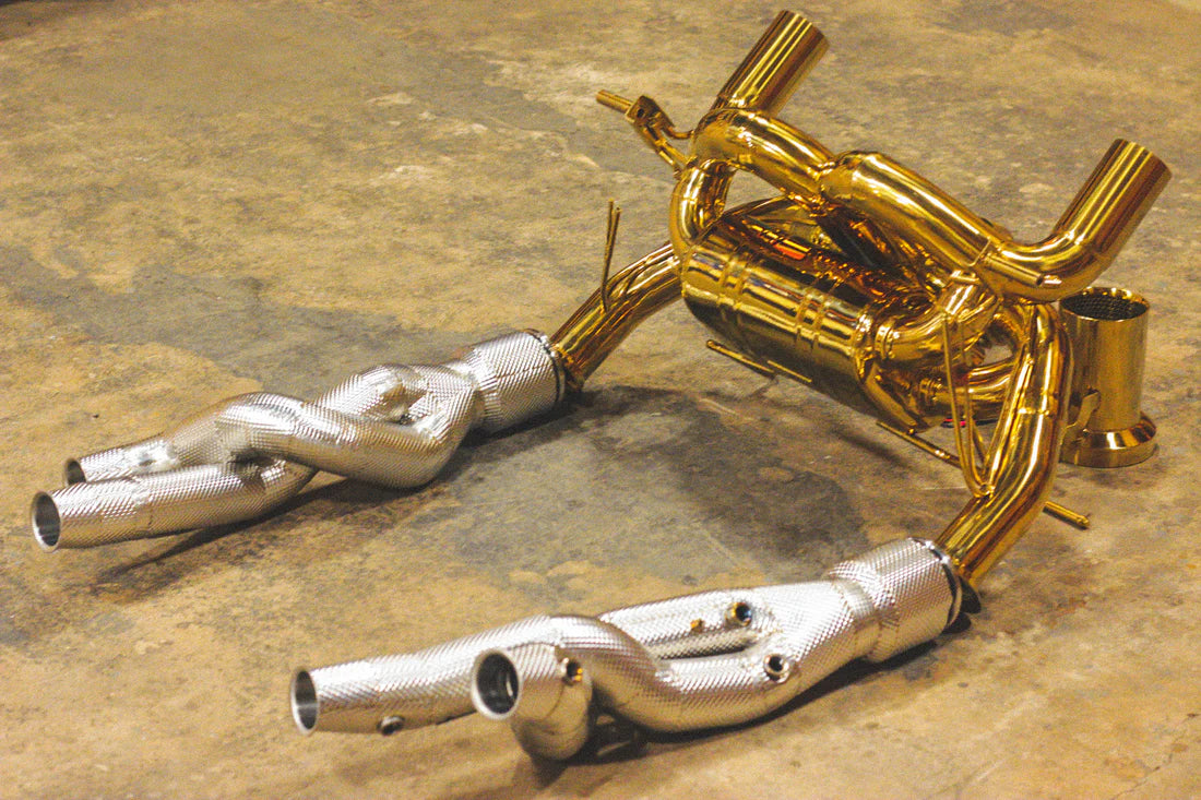 A side view of Valvetronic Designs Valved Sport Exhaust System with free flow front pipes on the ground (for Lamborghini Aventador SVJ/Ultimae).