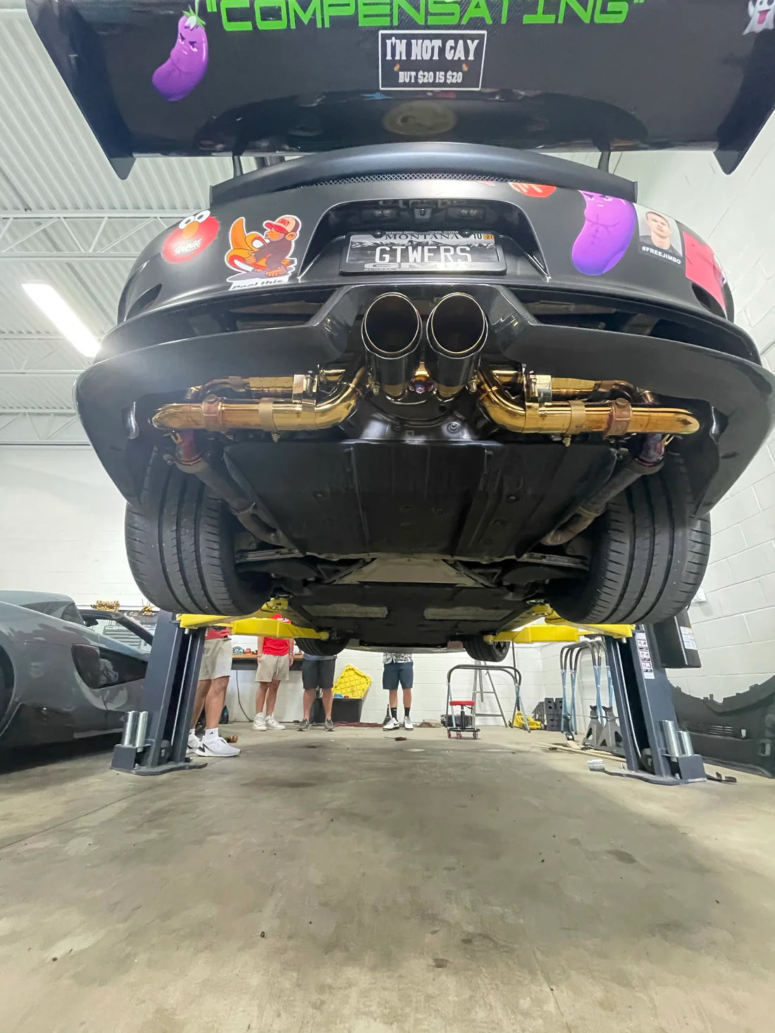 A wide view of Valvetronic Designs Valved Sport Exhaust System fitted on a lifted car from the back (for Porsche 991 GT3 / RS).