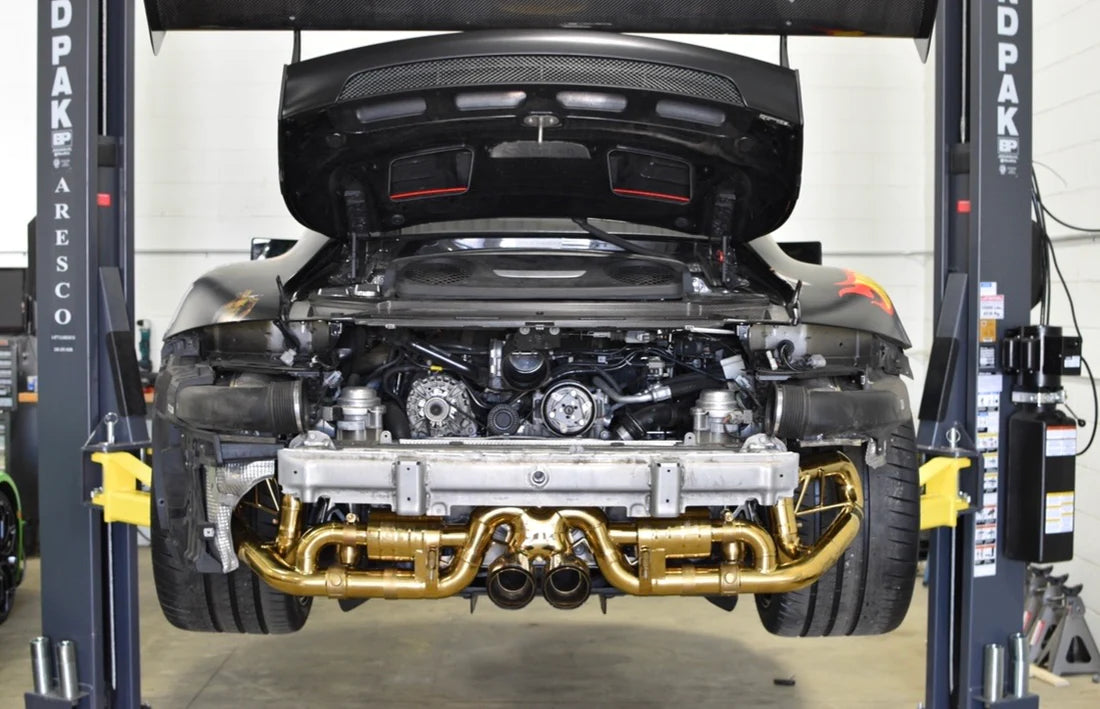 A wide view of Valvetronic Designs Valved Sport Exhaust System fitted on a lifted car from the back (for Porsche 991 GT3 / RS).