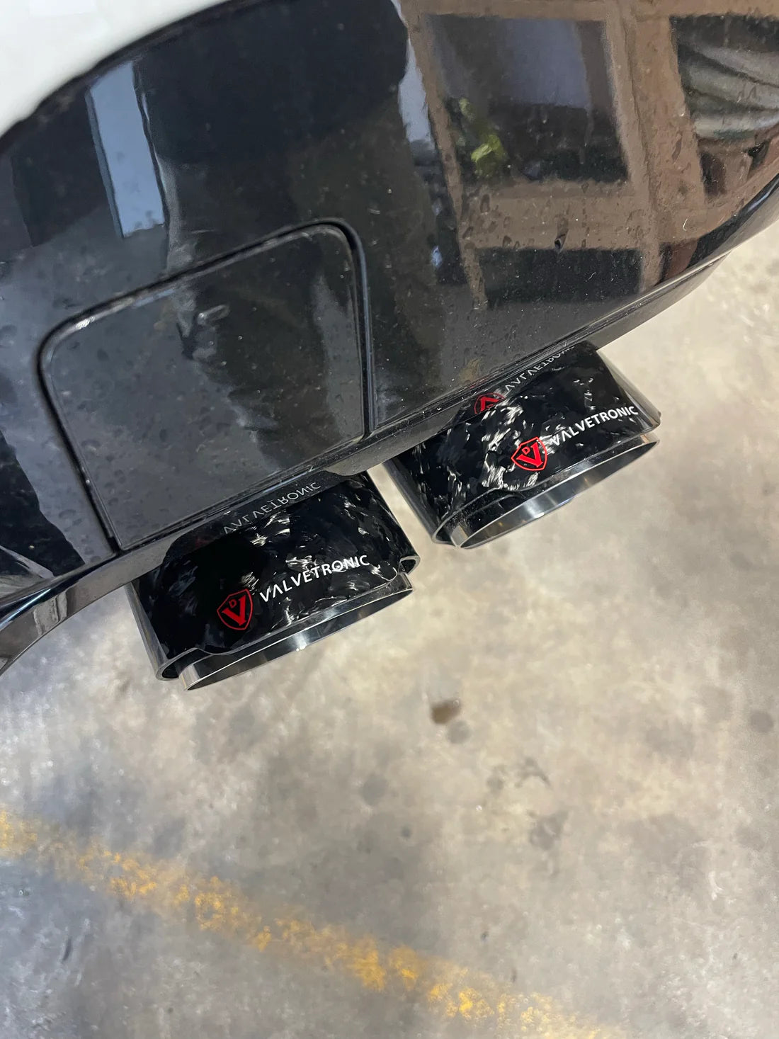 A close up view of Valvetronic Designs Valved Sport Exhaust System's exhaust tips fitted on a car (for BMW X3M F97 / X4M F98).