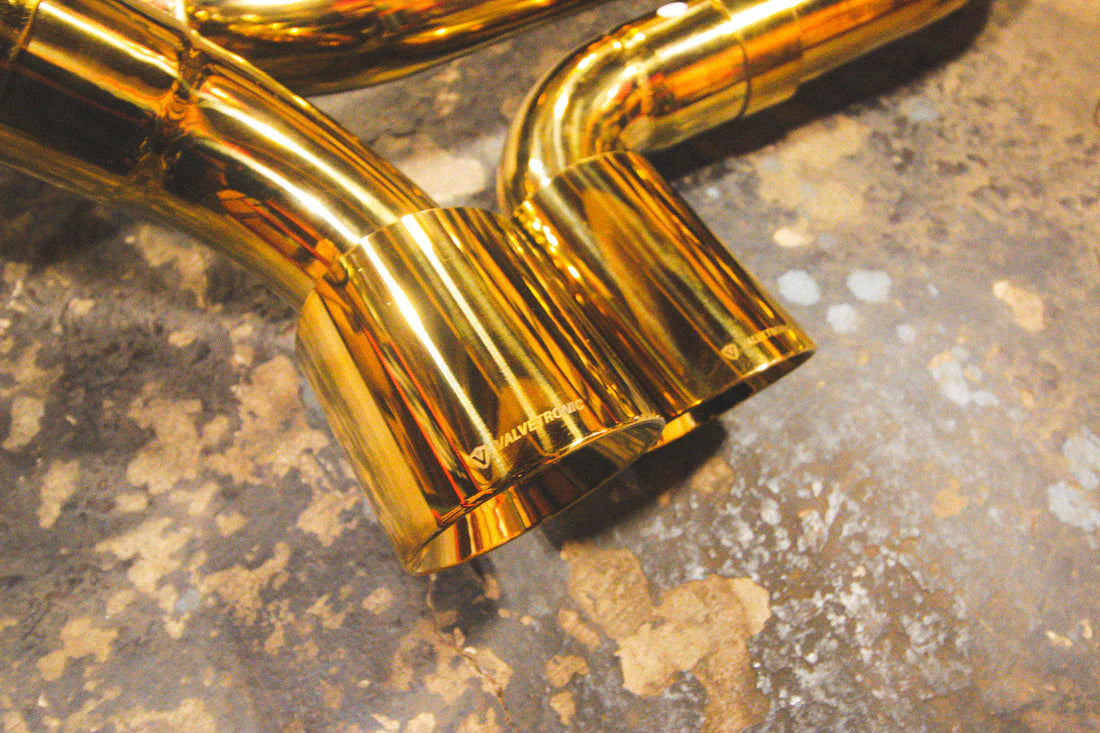 A close up view of Valvetronic Designs Valved Sport Exhaust System's exhaust tips on the ground (for Porsche 911 Carrera / S / GTS, Targa 4 / S / GTS).