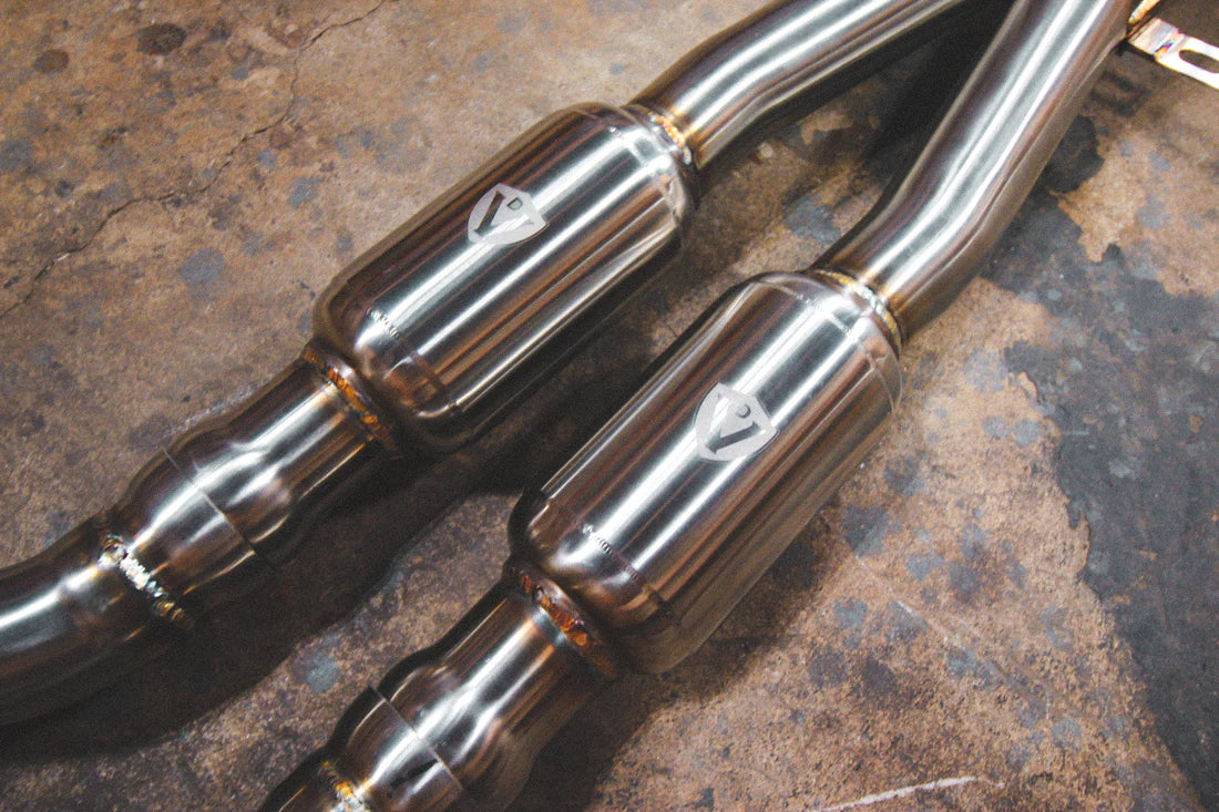 A close up view of Valvetronic Designs Midpipe V2 on the ground (for BMW M3 E9x).