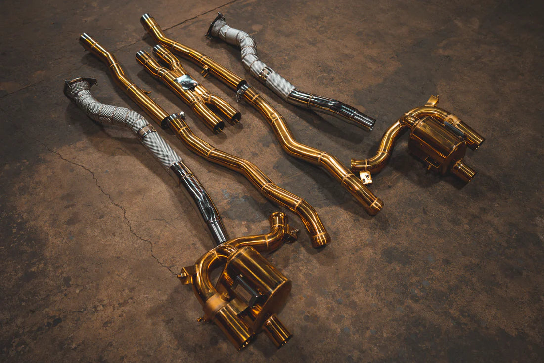 A side overview of Valvetronic Designs Ferrari Valved Exhaust system with free flow front pipes on the ground (for GTC4 Lusso).