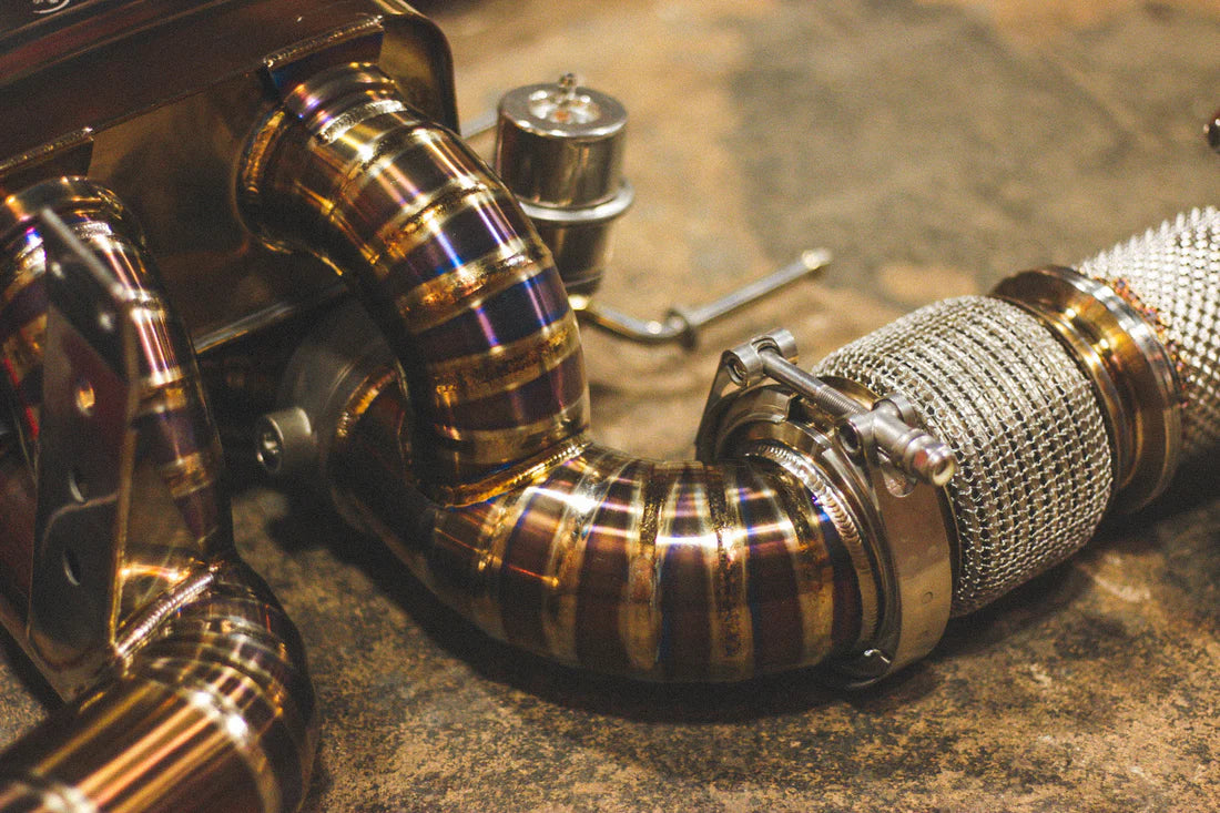 A close view of Valvetronic Designs Titanium Valved Sport Exhaust System's pipe on the ground (for Mclaren 720S).