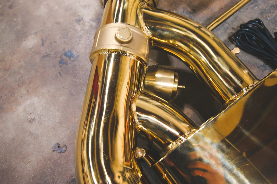 A close up view of Valvetronic Designs Valved Sport Exhaust System's pipes on the ground (for Nissan GTR R35).