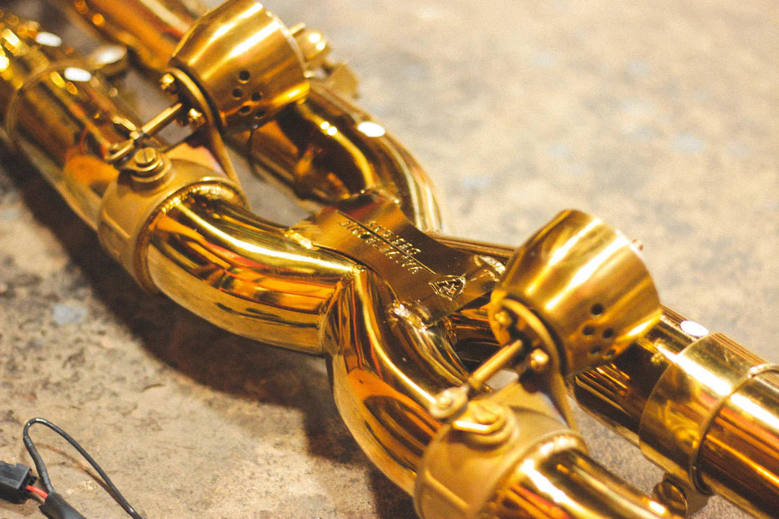 A side close up view of Valvetronic Designs Valved Sport Exhaust System on the ground (for Porsche 911 Carrera / S / GTS, Targa 4 / S / GTS).