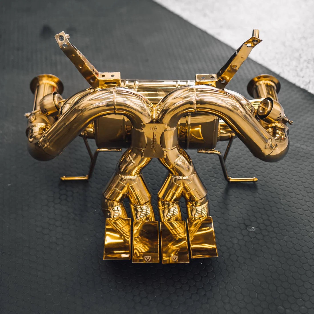 A top overview of Valvetronic Designs Valved Sport Exhaust System on a grey carpet on the ground (for Lamborghini Aventador LP700 / SV).