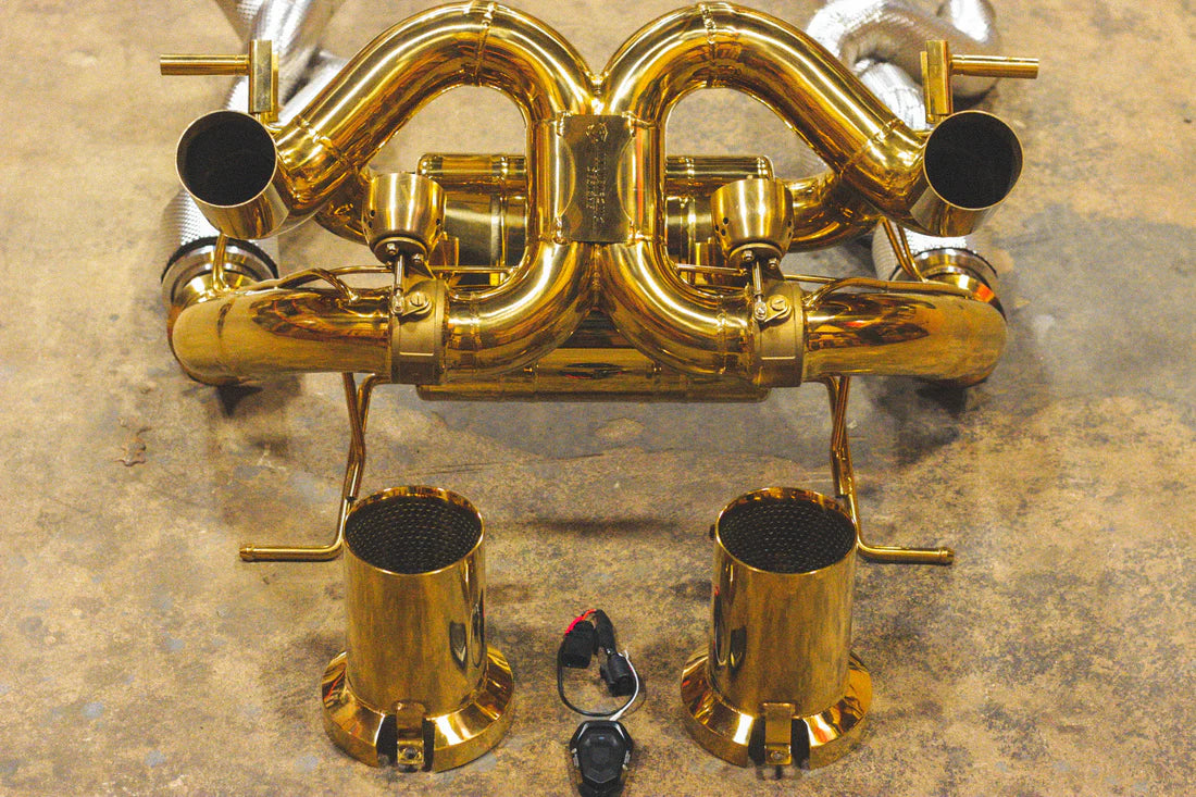 A close up view of Valvetronic Designs Valved Sport Exhaust System with valve controller on the ground (for Lamborghini Aventador SVJ/Ultimae).