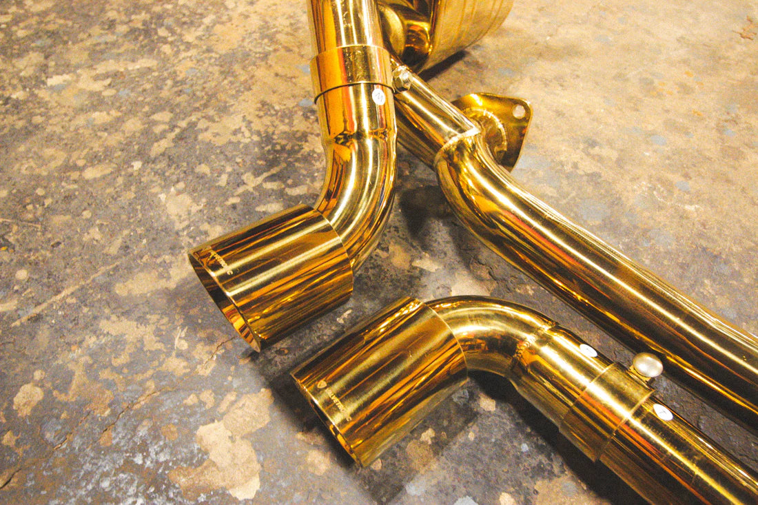 A close up view of Valvetronic Designs Valved Sport Exhaust System's exhaust tips on the ground (for Porsche 911 Carrera / S / GTS, Targa 4 / S / GTS).