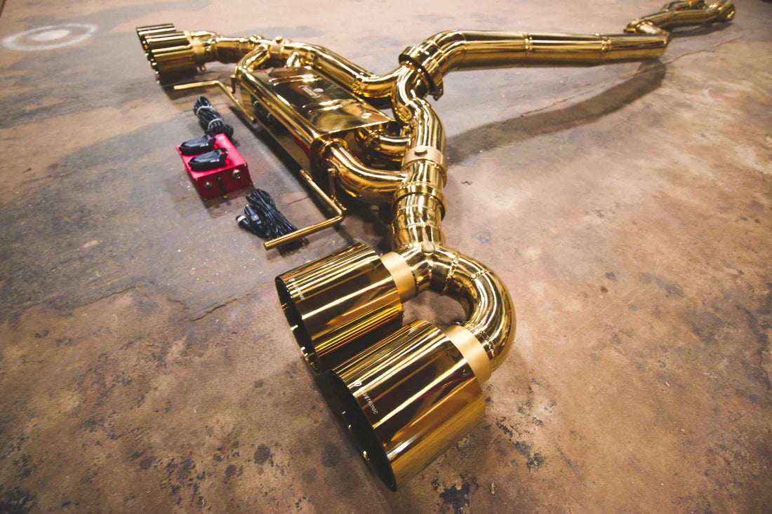 A side overview of Valvetronic Designs Valved Sport Exhaust System with valve controllers and wires on the ground (for Nissan GTR R35).