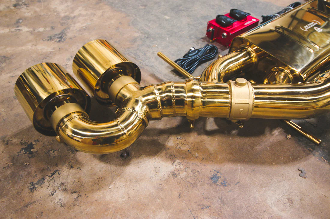 A back view of Valvetronic Designs Valved Sport Exhaust System's exhaust tips on the ground (for Nissan GTR R35).