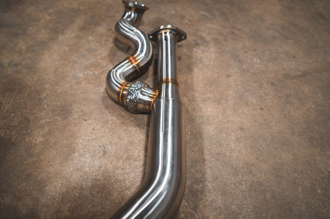 A close up overview of Valvetronic Designs Equal Length Midpipe in Brushed Stainless Steel on the ground (for BMW G8x M3 / M4).
