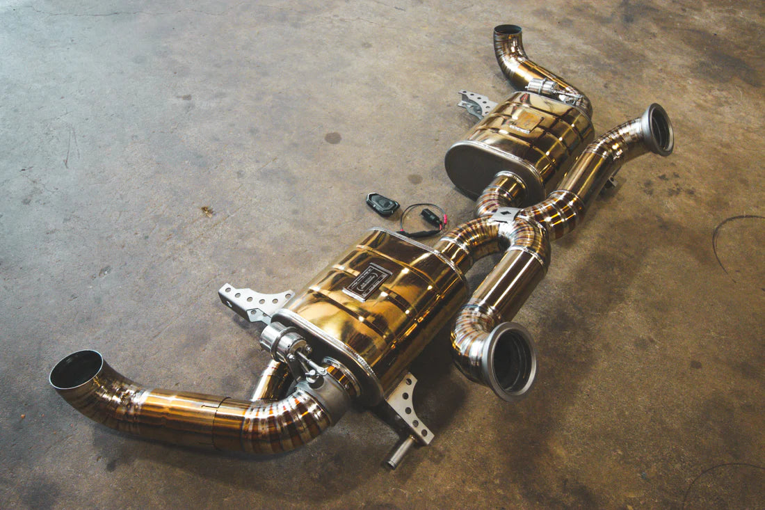 An overview of Valvetronic Designs gold Valved Sport Exhaust System (for Audi R8 V10 Gen 2 2017+)  with wires on the ground.