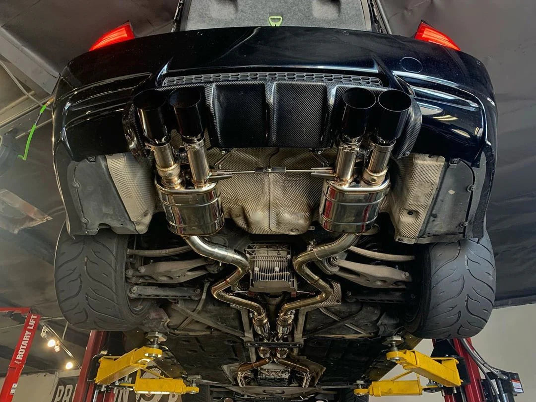 A close up view of Valvetronic Designs Midpipe V2 fitted on a lifted car (for BMW M3 E9x).