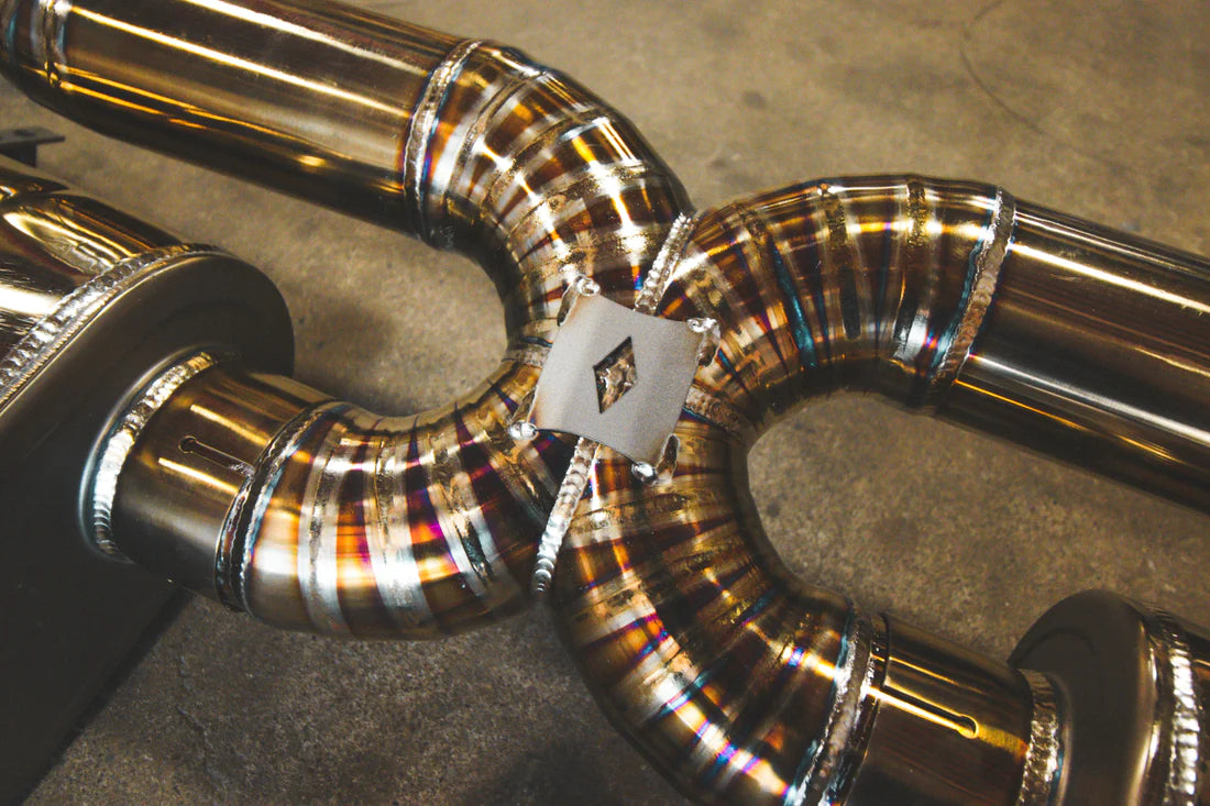 Pipes of Valvetronic Designs gold Valved Sport Exhaust System (for Audi R8 V10 Gen 2 2017+)  on the ground.