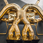 A close up of Valvetronic Designs Valved Sport Exhaust System on a grey carpet on the ground (for Lamborghini Aventador LP700 / SV).