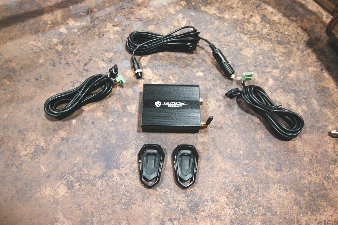 A close up view of Valvetronic Designs Valved Sport Exhaust System's valve controller and wires on the ground (for BMW X5M F85 / X6M F86).