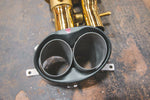 A close up of pipes of Valvetronic Designs gold Valved Sport Exhaust Sytem (for Audi RS6 / RS7 C7) on the ground.