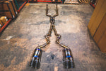A top overview of Valvetronic Designs Titanium Grade 5 Valved Sport Exhaust System with Black exhaust tips on the ground (for BMW F10 M5 / F12 M6 / F06 M6).